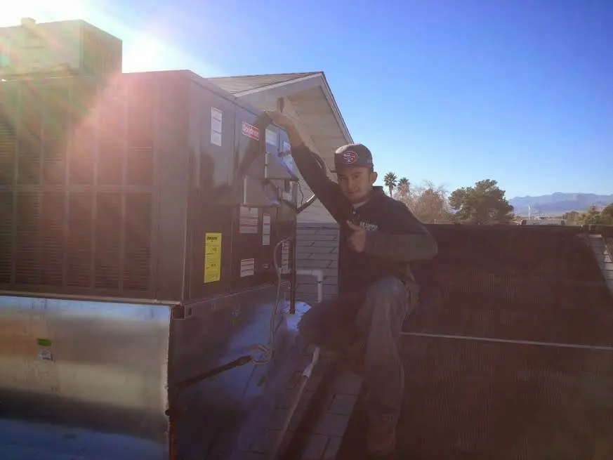 HVAC technician performing HVAC Inspection on a rooftop unit in Modesto
